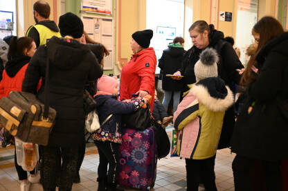 Žene i djeca iz Ukrajine na željezničkoj stanici u Poljskoj, grad Przemysl. Građani napuštaju Ukrajinu zbog rata. Porodice se sele na Zapad. Ljudi sa koferima čekaju voz.