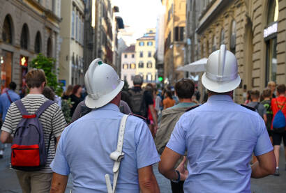 Policajci patroliraju gradom u Italiji. Policajci u uniformama i sa bijelim šljemovima.