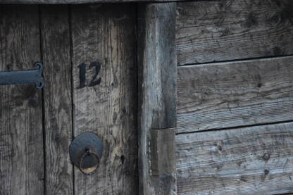 Ulazna vrata u jedan od mlinčića na Plivskom jezeru sa brojem 12 na vratima iznad stare kvake na vratima.