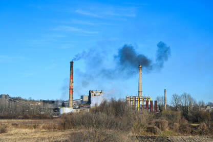 Teško industrijsko onečišćenje zraka iz dimnjaka. Crni otrovni dim iz industrijske zone. Onečišćenje okoliša puhanjem tvorničkog dimnjaka.