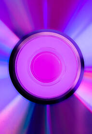 Stari CD, DVD disc, disk, snimljen izbliza na pink pozadini sa gradacijom prelijepih reflektirajućih pastelnih boja - plave, ljubičaste i roze boje.