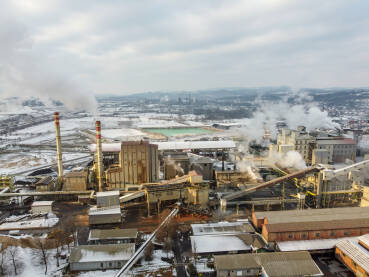 Dimnjaci iz tvornice zagađuju okoliš. Industrijsko onečišćenje zraka iz fabrike. Otrovni dim iz dimnjaka u industrijskoj zoni tokom zime. Industrijski kompleks, snimak dronom.