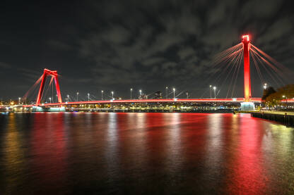 Rotterdam, Holandija. Crveni most noću. Willemsbrug most u Rotterdamu, Nizozemska. Moderna arhitektura.