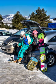 Djevojke se spremaju za ski stazu. Oblačenje ski opreme na parkingu u gepeku. Skijalište Kupres.
