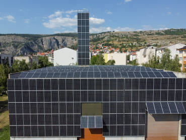 Solarni paneli na krovu objekta. Snimak dronom na solarne panele na vrhu zgrade. Proizvodnja čiste obnovljive energije iz sunca. Fotonaponske solarne ćelije. Električna energija.