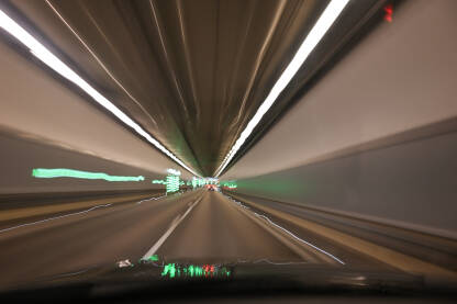 Zamućena fotografija cestovnog tunela. Pospana vožnja. Umoran ili pijan vozač za volanom. Prijevoz. Noćna vožnja kroz mračni tunel. Pogled vozača.