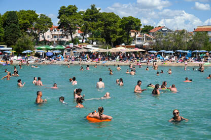 Ljudi u moru tokom turističke sezone. Jadransko more. Ljetovanje. Turisti na odmoru.