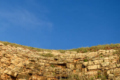 Osunčana zlatna stijena tokom vedrog dana.