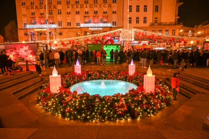 Zagreb, Hrvatska. Advent u Zagrebu. Praznične gužve u čarobnom adventskom slavlju u okićenom gradu. Ljudi šetaju kroz blistave praznične ulice i trgove tokom praznika. Praznični ukrasi.