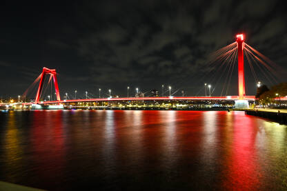 Veliki crveni most preko rijeke noću. Rotterdam, Nizozemska.