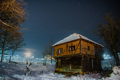 Napuštena stara krajiška kuća u zvijezdanoj hladnoj zimskoj noći.