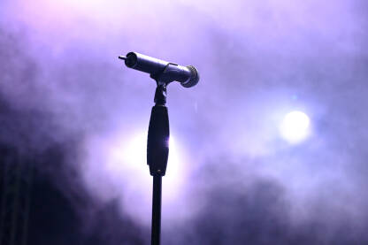 Mikrofon na bini. Vokalni mikrofon sa maglom i svjetlima u pozadini. Koncert.