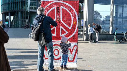 Berlin, Njemačka: Očuvani dio Berlinskog zida. Ostaci originalnog Berlinskog zida sa znakom mira na njemu. Popularna turistička destinacija.