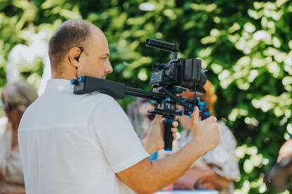 Snimatelj snima događaj,  kamera na ramenu