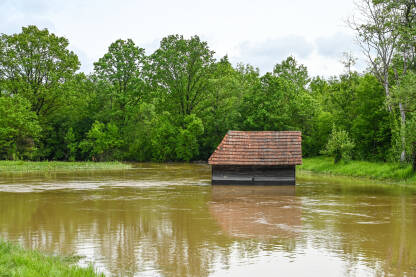 Poplavljena štala u polju. Poplave u proljeće. Mutna voda.