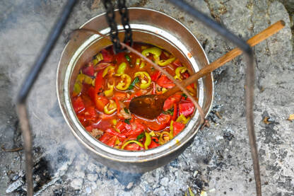 Povrće i meso se kuhaju u bakrenom loncu na vatri. Bosanski ili Hercegovački lonac.