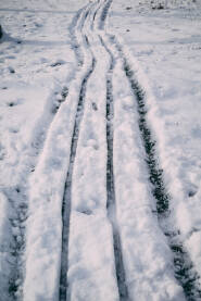 Snijeg, snijeg prekrio ogradu i travu, tragovi sanki