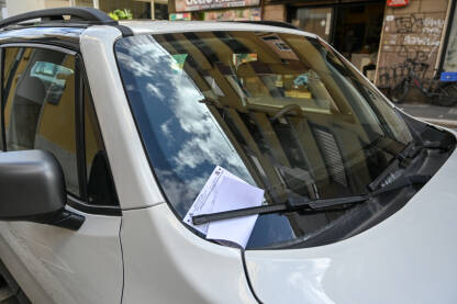 Obavještenje o prekršaju parkiranja na vjetrobranskom staklu automobila. Kazna za parkiranje postavljena na vjetrobransko staklo vozila. Vozilo u prekršaju.