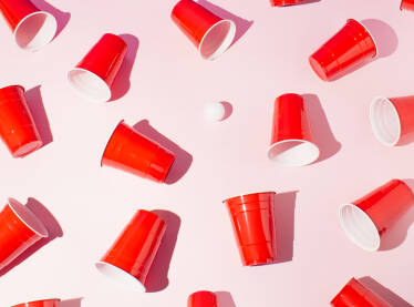 Crvene plastične čaše za beer pong na roze pozadini.
