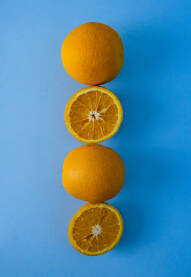 Sočna narandža na plavoj podlozi, koja je prerezana na pola.