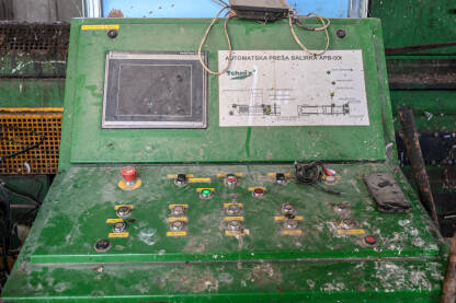 Upravljačka konzola na mašini u fabrici. Stari kontrolni panel na proizvodnoj liniji. Mnogo dugmadi, prekidača i instrumenata. Industrija. Kontrolna tabla, krupni plan.