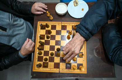 Stariji ljudi igraju šah. Partija šaha. Šahovska ploča i figure na stolu. Muškarci igraju šah. Šahisti.