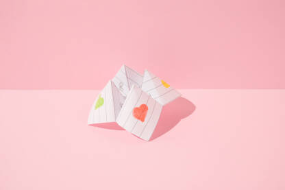 Papirna igra proricanja sudbine - žaba gatalica na ružičastoj pozadini.
