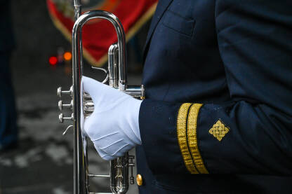 Muzičar sa trubom. Vojnik u bijelim rukavicama svira trubu. Vojni orkestar na paradi.