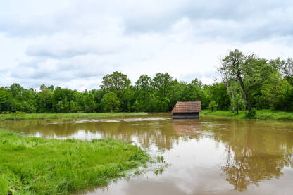 Poplavljena štala u polju. Poplave u proljeće. Mutna voda.