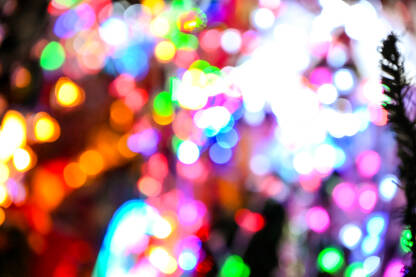 Zamućena novogodišnja i božićna svjetla. Mnoštvo šarenih svjetlećih ukrasa. Led lampice. Bokeh.