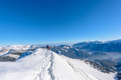 Planinari prilikom hodanja grebenom planine Hajla.Greben je priroddna granica Crne Gore i Kosova.U daljini magla i sniježni vrhovi Šar planine,koja se nalazi u Sj.Makedoniji.