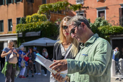 Turisti razgledaju mapu tokom obilaska grada. Turisti na putovanju.