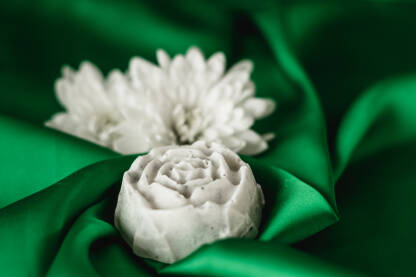 Prirodni sapuni na zelenoj svili. Sapun u obliku ruže. Mirisni sapun kao poklon.