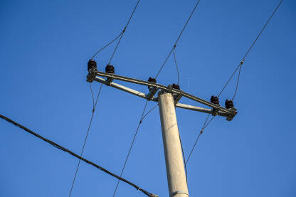Betonski stub sa okačenim kablovima. Dalekovod. Visokonaponska električna žica.