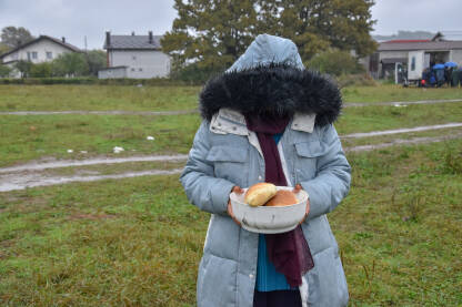 Žena u improvizovanom kampu u Velikoj Kladuši, Bosna i Hercegovina. Migranti i izbjeglice dobijaju hranu od lokalnih volontera. Žena drži hranu koju je dobila od lokalnih stanovnika.