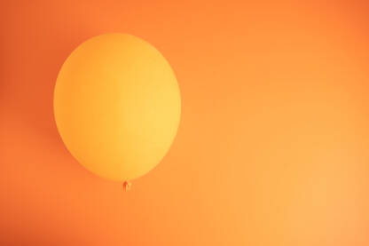 Narandžasti balon na istojojnoj podlozi sa prazni prostorom za pisanje, tekst, reklamu, copy space.