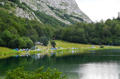 Mnoštvo šatora i kampera uz jezero na planini. Trnovačko jezero, Maglić.