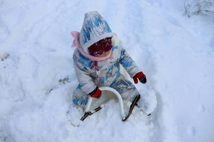 Dijete na sankama u snijegu