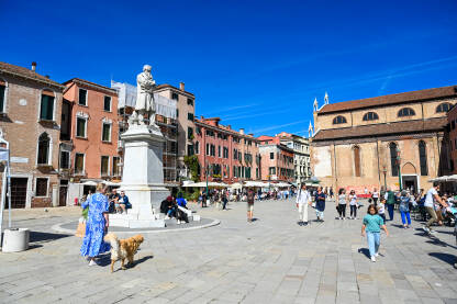 Trg u Veneciji, Italija. Ljudi na gradskom trgu. Turisti u gradu.