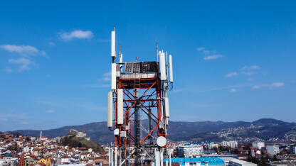 GSM i radio telekomunikacioni toranj u gradu. Toranj mobilnih telefona, snimak dronom. Bazna primopredajna stanica. Bežični komunikacioni antenski predajnik.
