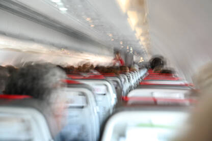 Turbulencija u avionu. Putnici u kabini tokom turbulentnog leta. Zamućena fotografija u avionu. Putovanje avionom. Strah od letenja.