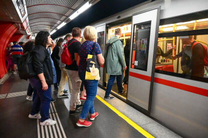 Beč, Austrija: Putnici na stanici podzemne željeznice. Voz na stanici. Željeznica. Javni prijevoz. Ljudi ulaze i izlaze iz metroa.