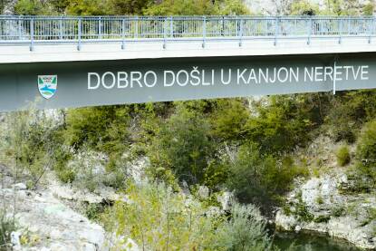 Most preko rijeke Neretve za selo Kašići. Natpis ispisan na mostu: Dobro došli u kanjon Neretve