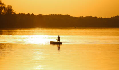 Zalazak sunca na rijeci Savi, ribar u čamcu