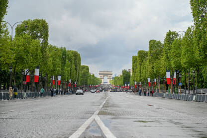 Pariz, Francuska: Avenija Champs-Élysées. Poznata avenija proteže se od Slavoluka pobjede do Trga Concorde. Mnogo zastava Francuske na ulici.