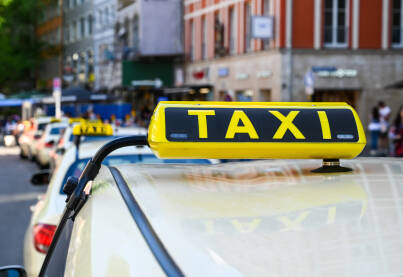 Taksi. Taxi znak na krovu automobila. Prijevoz. Taksi u gradu.