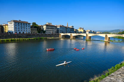 Firenca, Italija: Turisti u čamcima i kajacima na rijeci Arno. Ljudi istražuju grad.