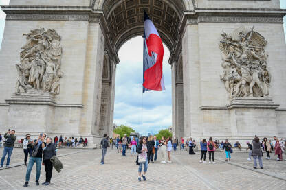 Pariz, Francuska: Trijumfalna kapija u centru grada. Ljudi posjećuju popularnu turističku atrakciju i historijski spomenik u Parizu.