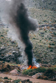 Zapaljeno smeće na divljoj deponiji smeća.