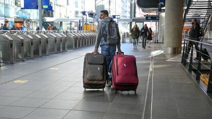 Putnik sa koferima na željezničkoj stanici. Muškarac sa torbama.
